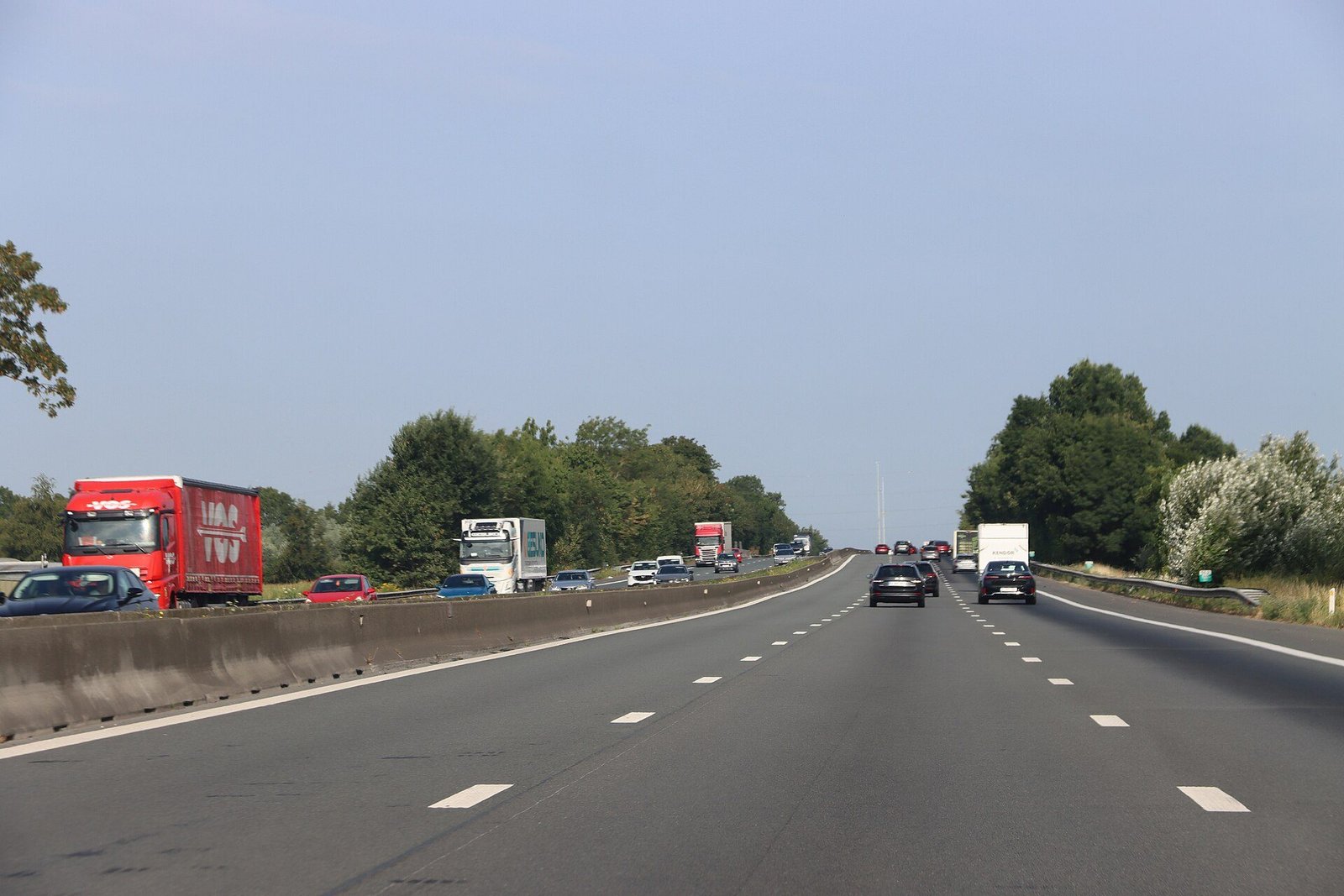 Auto's en vrachtwagens op de E40-autosnelweg in Vlaanderen bij helder weer